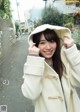 A woman in a white coat is posing for a picture.