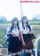 Two young women in school uniforms standing next to each other.