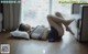 A woman laying on the floor in front of a window.