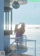 A couple of women standing on top of a pier next to the ocean.